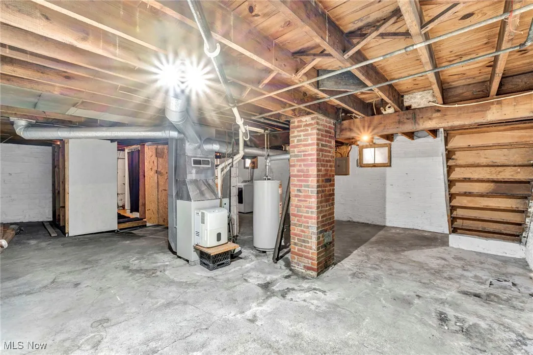 Basement featuring water heater, heating unit, washer / clothes dryer, and electric panel