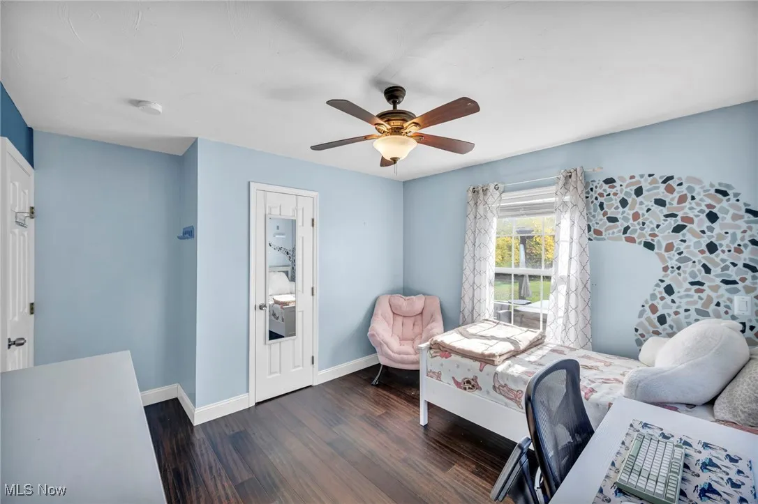 Bedroom with dark wood-style flooring and ceiling fan