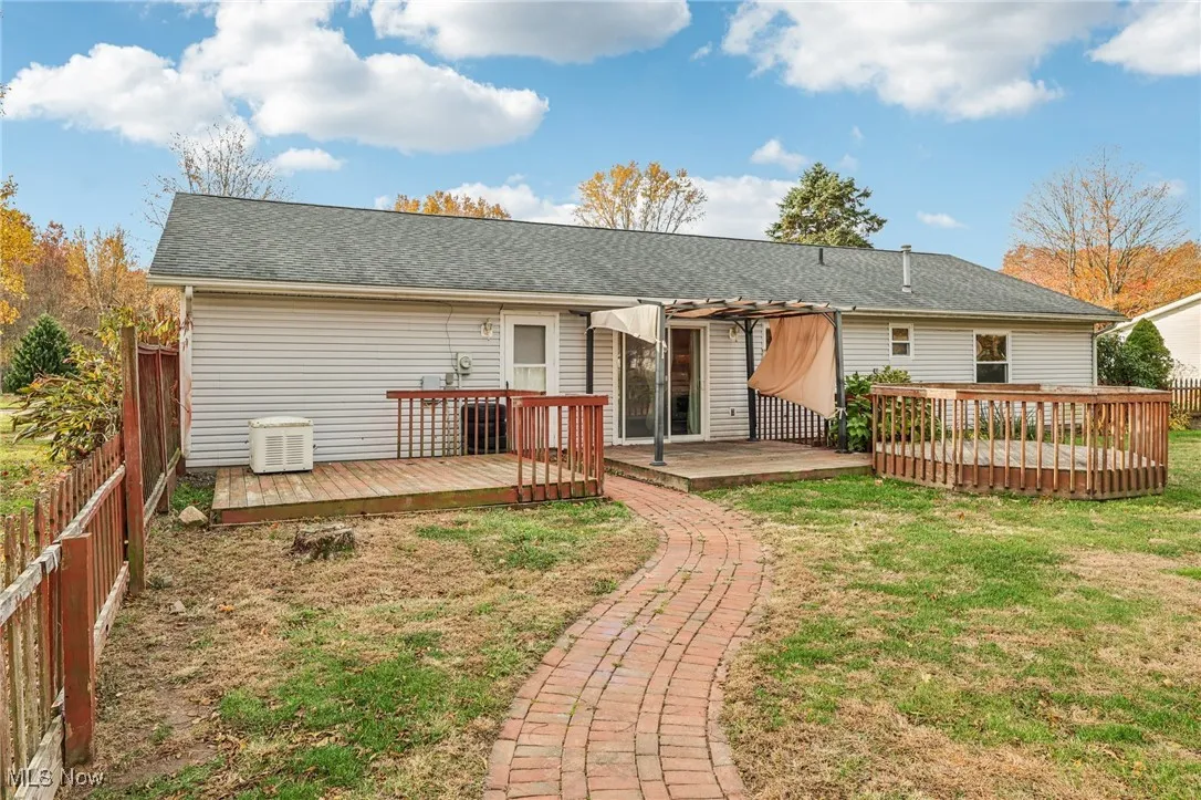 Rear view of house with a wooden deck and roof with shingles