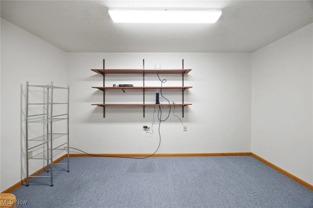 Spare room featuring a textured ceiling and light colored carpet
