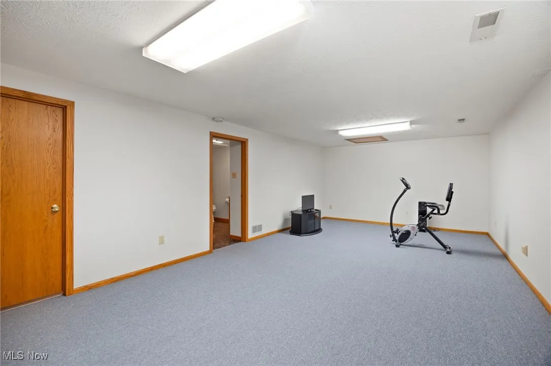 Exercise area with carpet and a textured ceiling