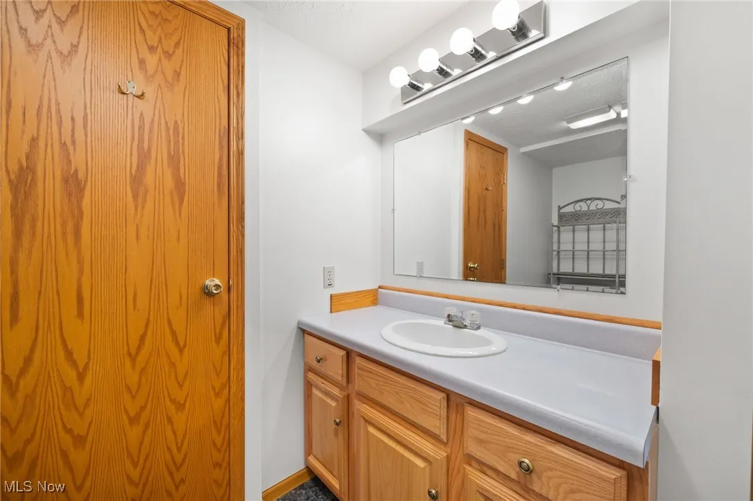 Half bathroom with vanity and a textured ceiling