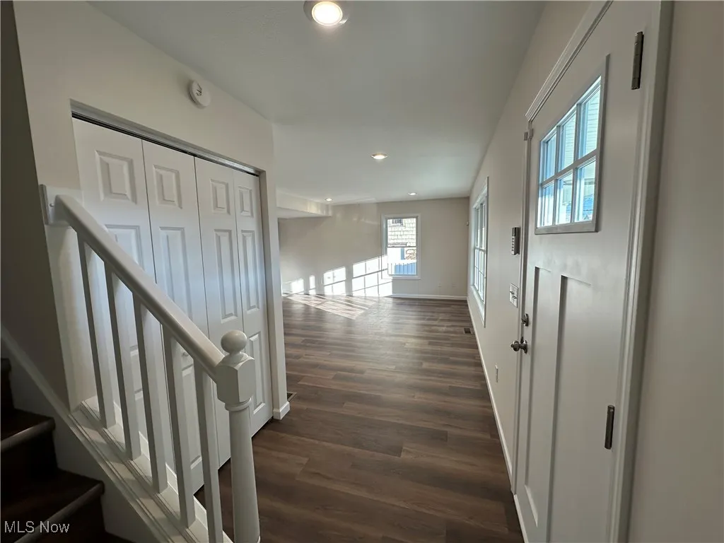 Hallway with recessed lighting, stairs, and dark wood-style flooring