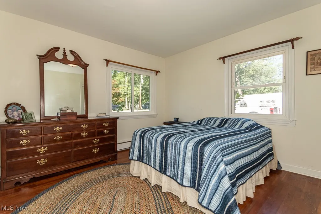Bedroom featuring dark wood finished floors and a baseboard radiator