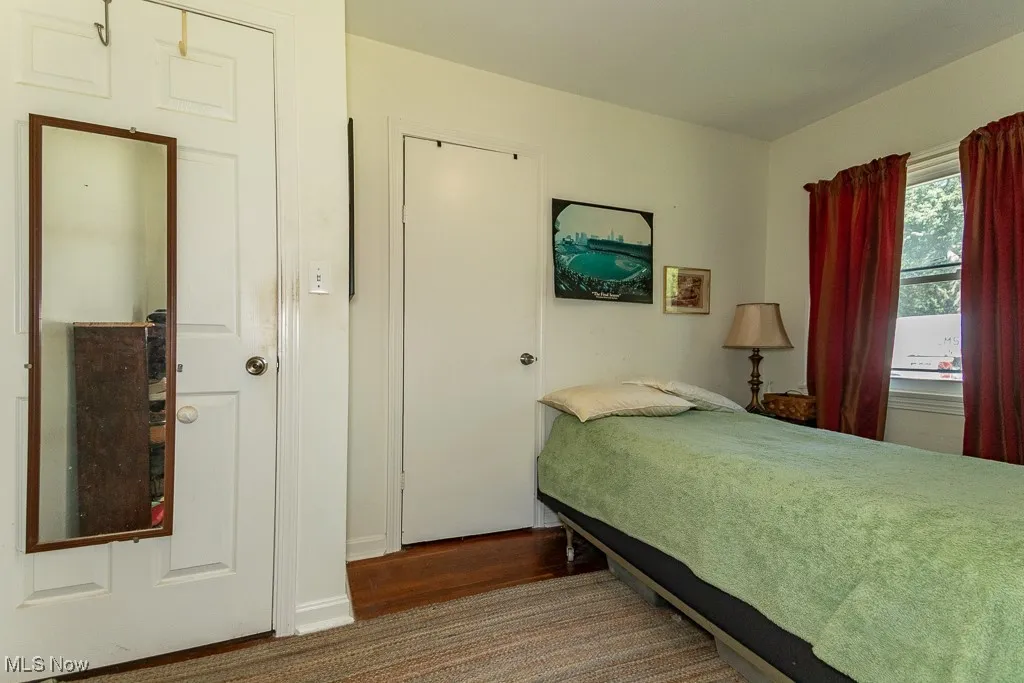 Bedroom with baseboards and dark wood-type flooring