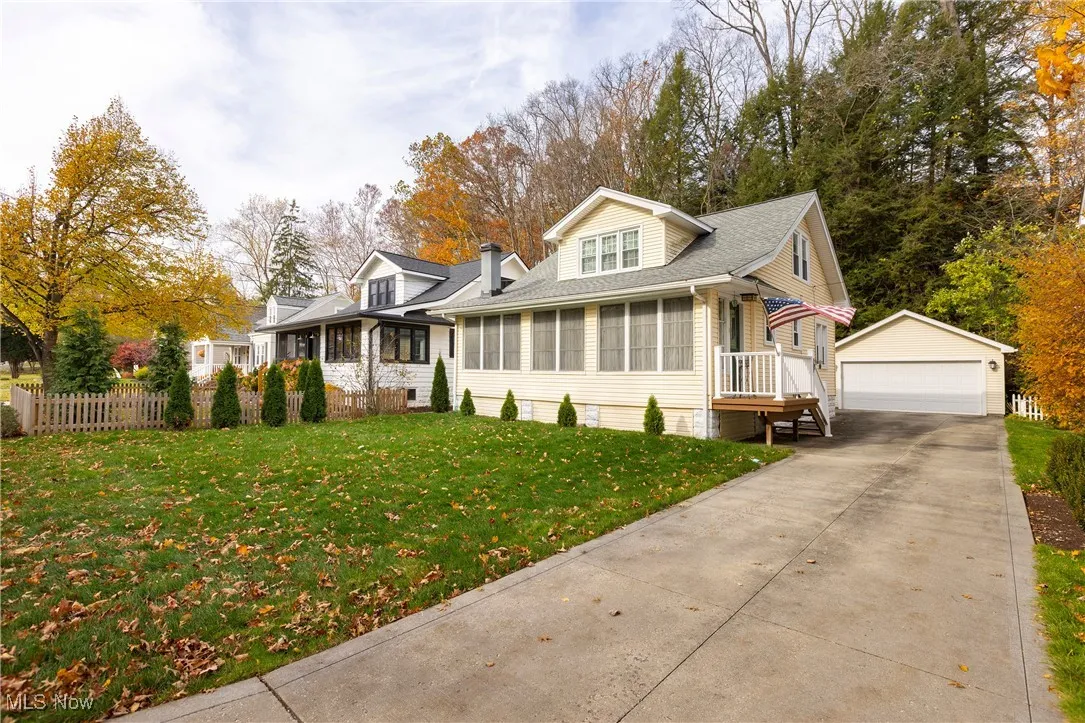View of front facade featuring, a newer garage, and view of wooded area