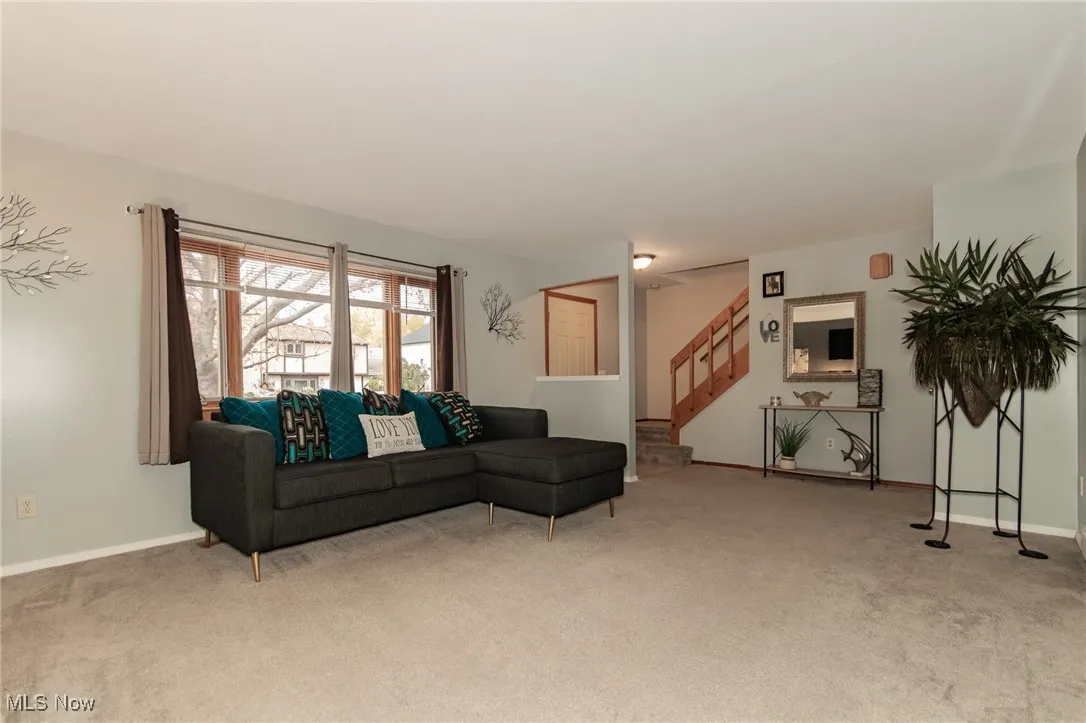 Living area with carpet floors and stairway