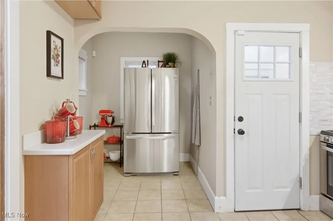 Kitchen with appliances with stainless steel finishes, light countertops, plenty of natural light, and light tile patterned floors