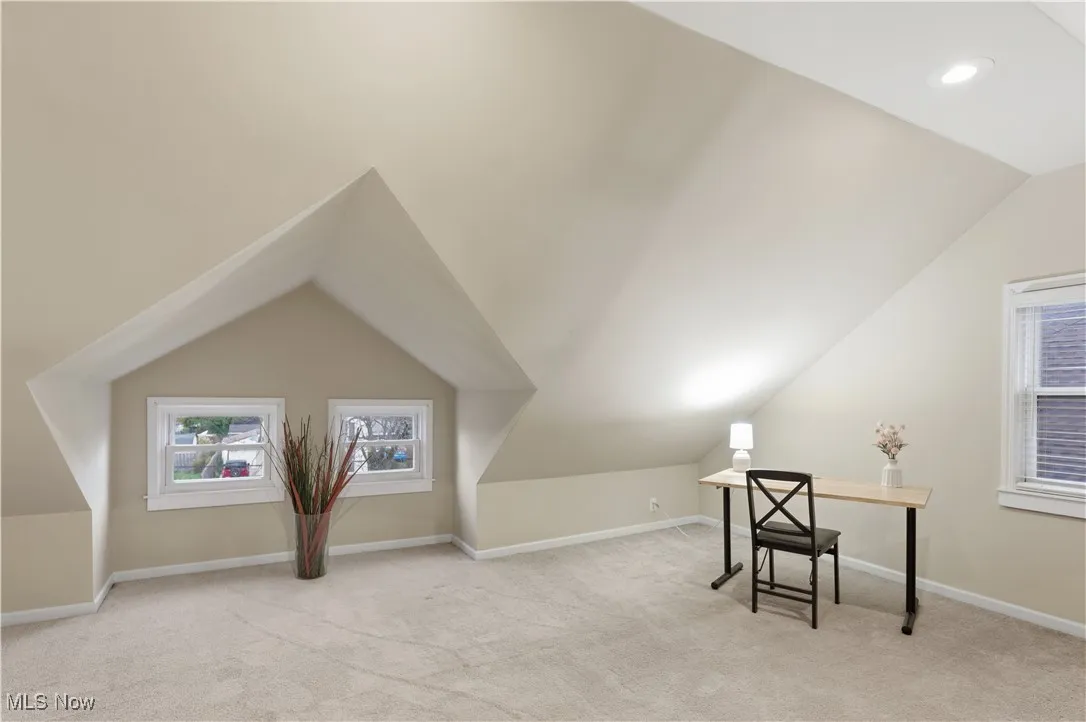 Home office featuring light carpet and lofted ceiling