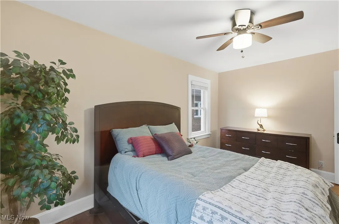 Bedroom with a ceiling fan and dark wood-type flooring