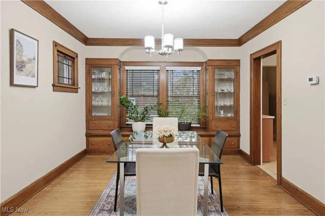 Dining room featuring crown molding, a chandelier, and light wood finished floors