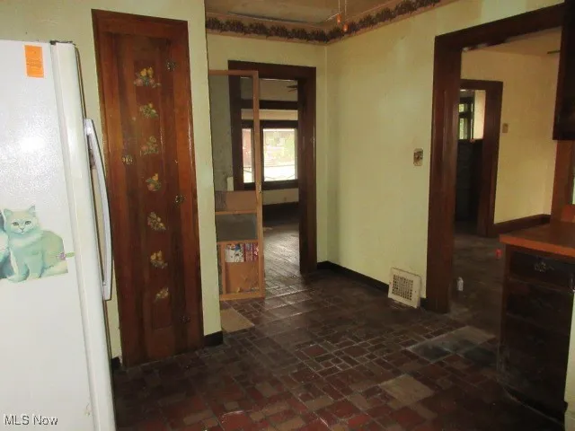 Hall with brick floors and baseboards