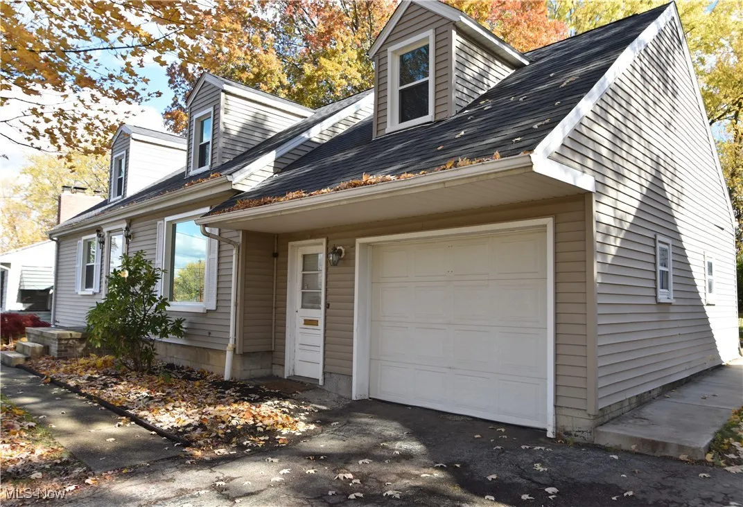 View of front of home featuring roof with shingles and a garage