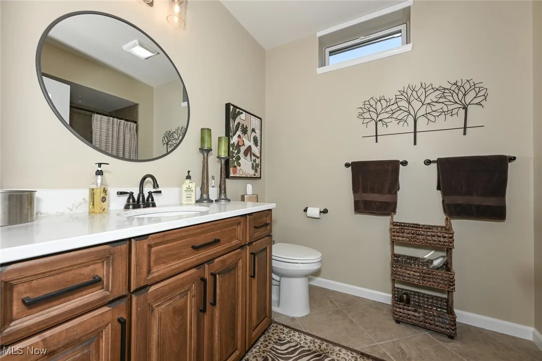 Bathroom featuring a shower with curtain, vanity, and light tile patterned flooring