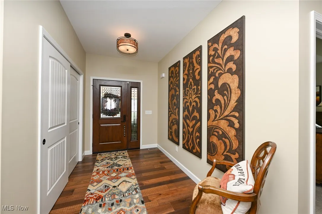 Entryway with dark wood-style floors and baseboards
