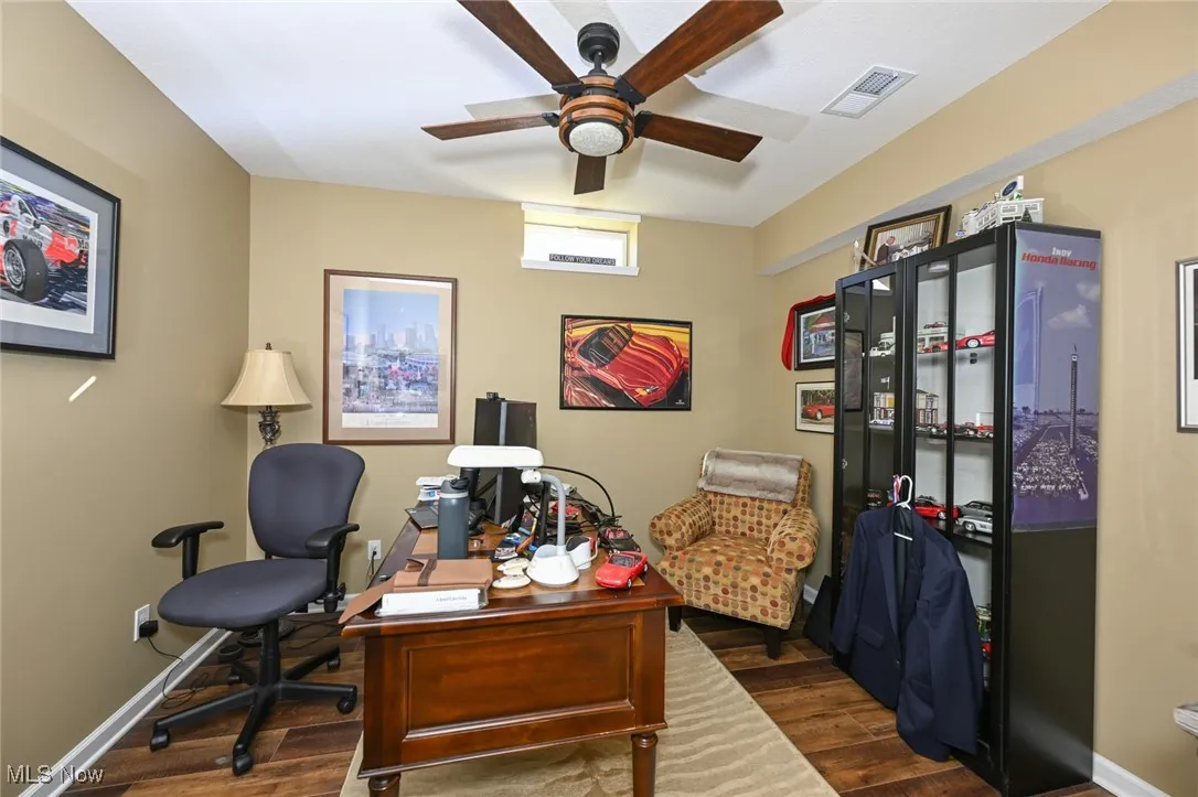 Office area featuring dark wood finished floors and a ceiling fan