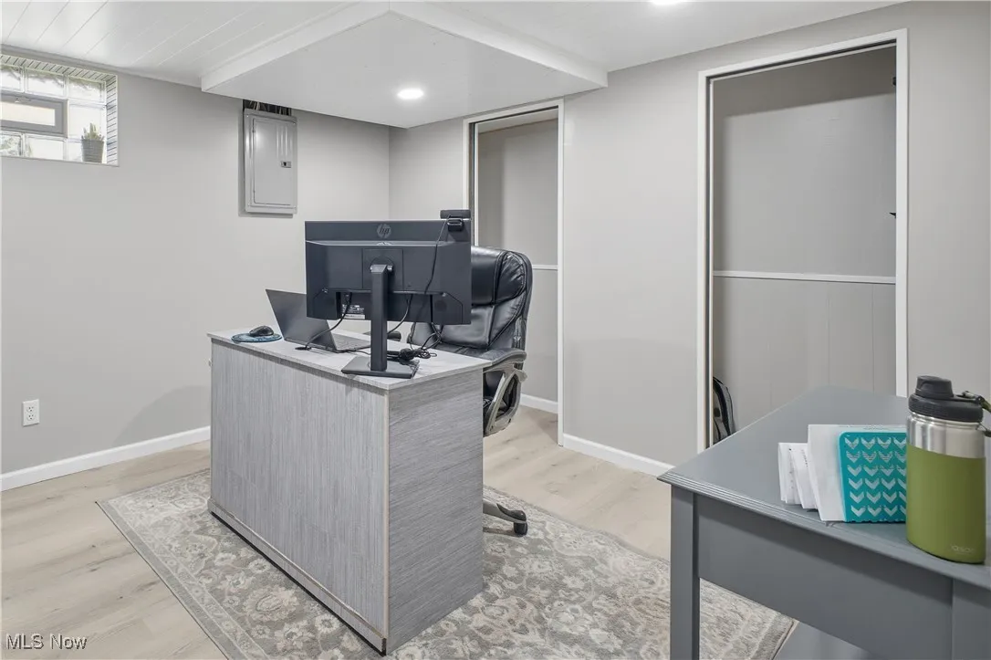 Office space featuring light wood-style floors, electric panel, and recessed lighting