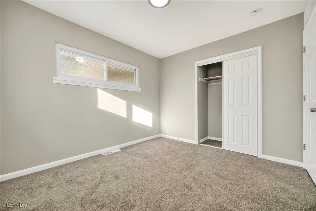 Unfurnished bedroom with carpet and a closet