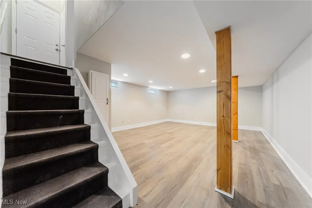 Stairway with wood finished floors and recessed lighting