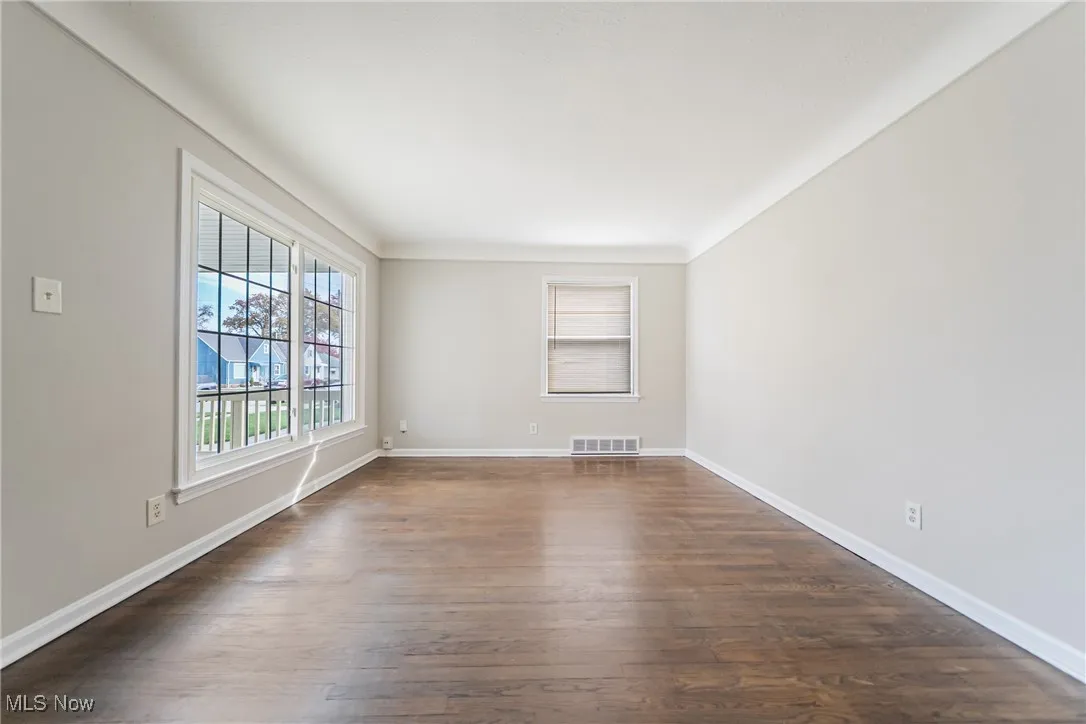 Unfurnished room with dark wood-style floors and baseboards