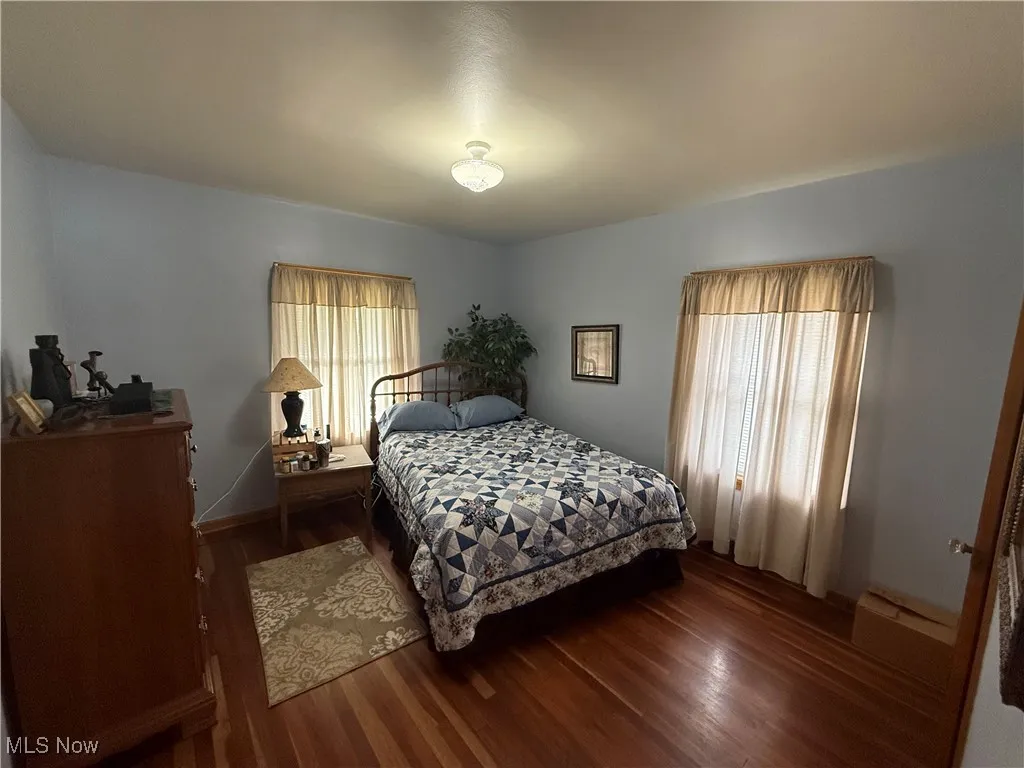 Bedroom featuring wood finished floors and baseboards