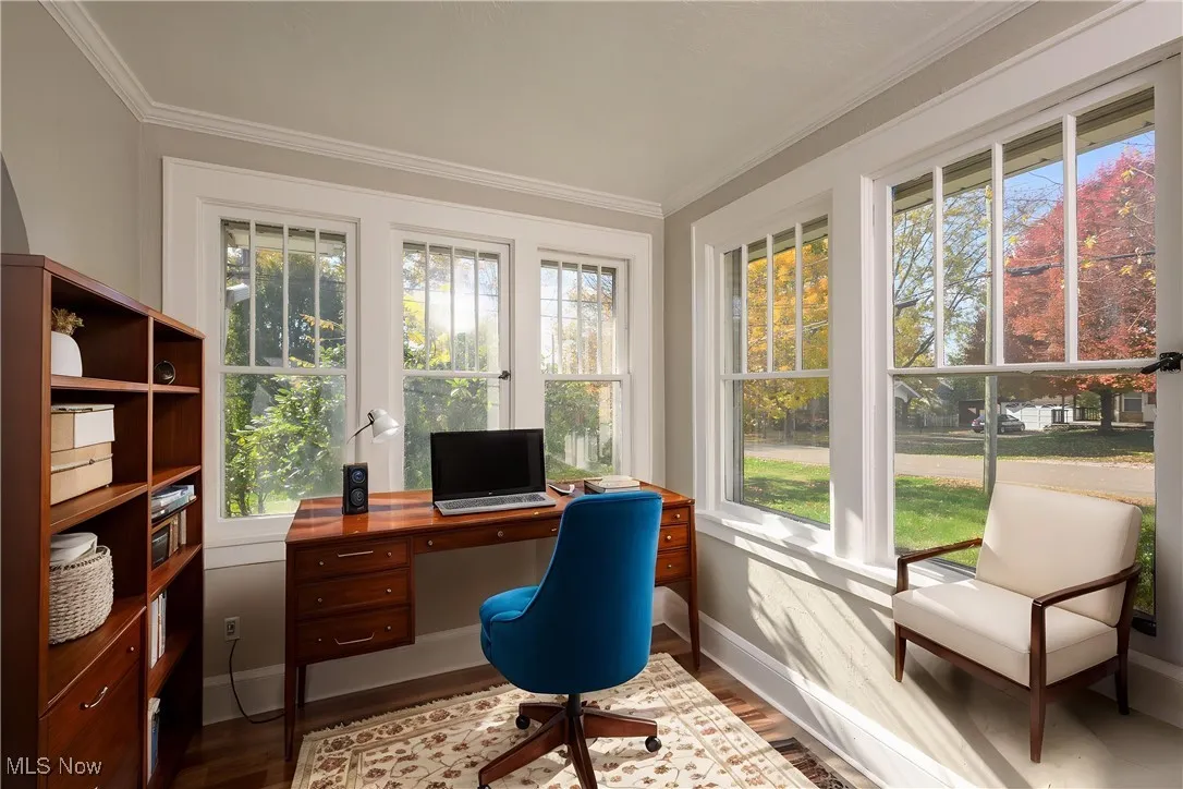Home office with healthy amount of natural light, dark wood-style flooring, and ornamental molding.  Created by AI

