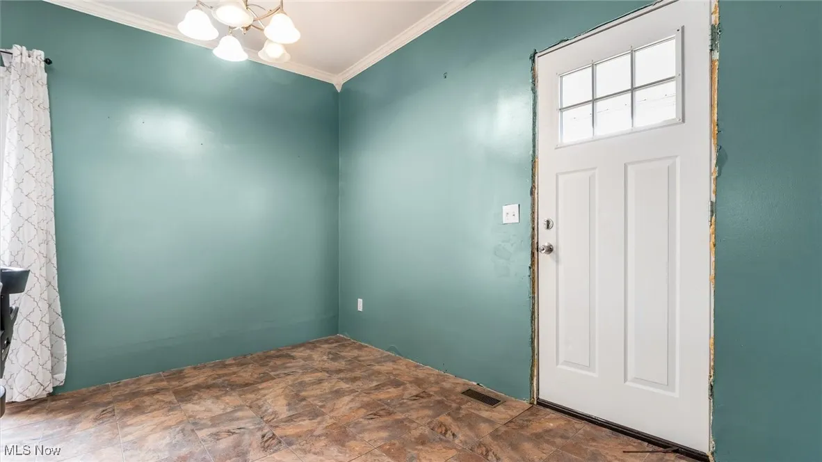 Foyer entrance featuring a chandelier and ornamental molding