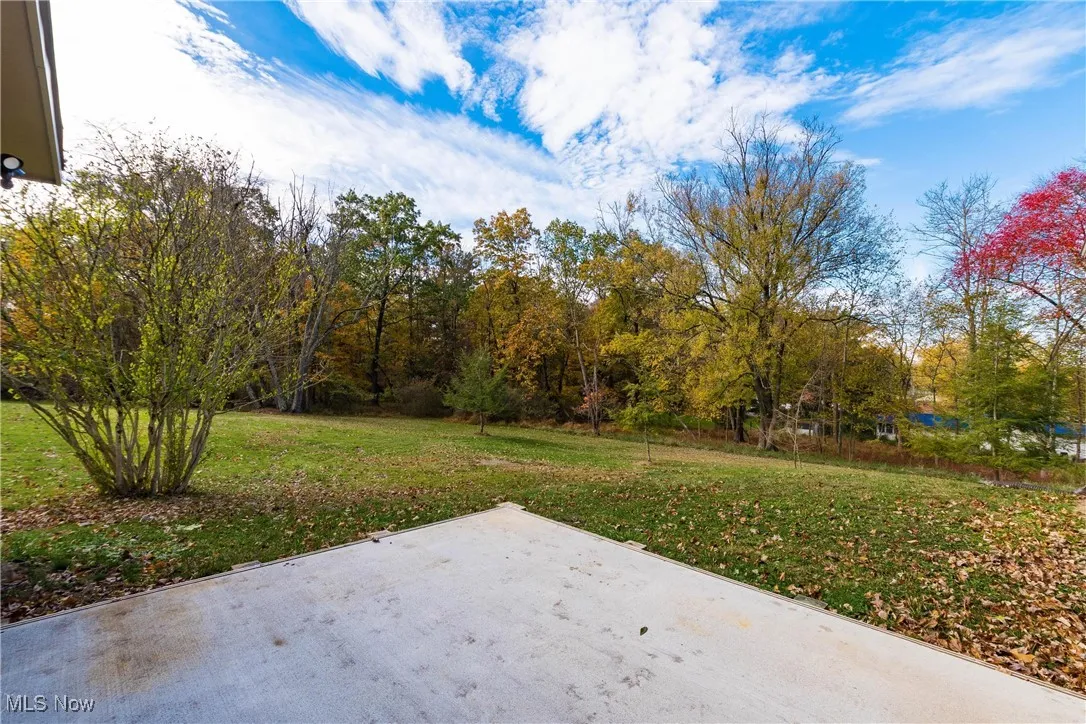 View of grassy yard featuring a patio