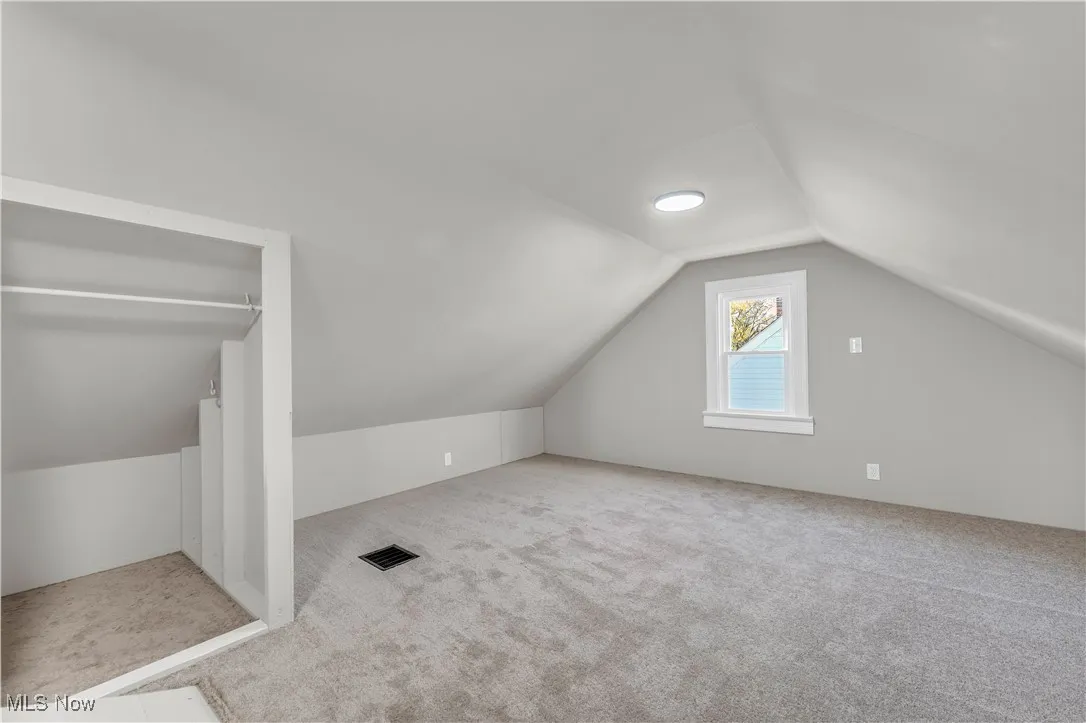 Bonus room with vaulted ceiling and carpet