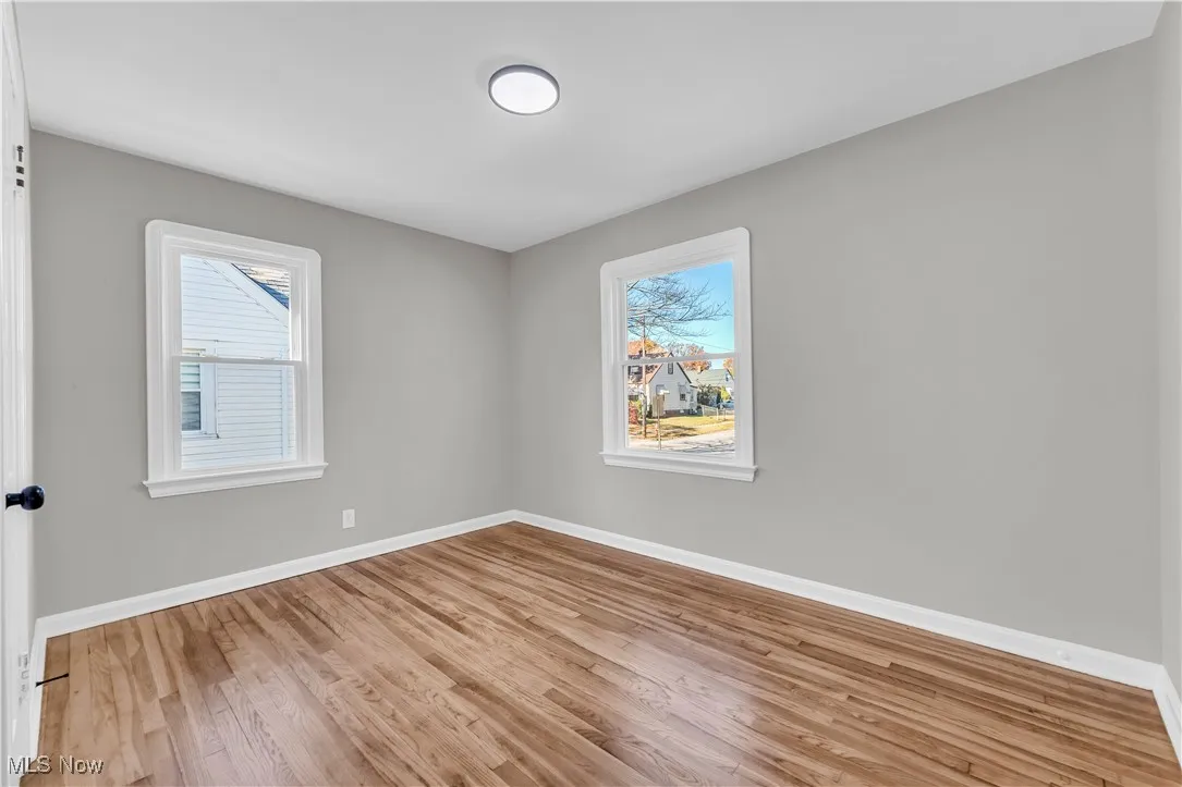 Unfurnished room featuring light wood-type flooring and healthy amount of natural light