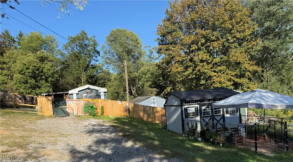 Fenced backyard featuring a shed