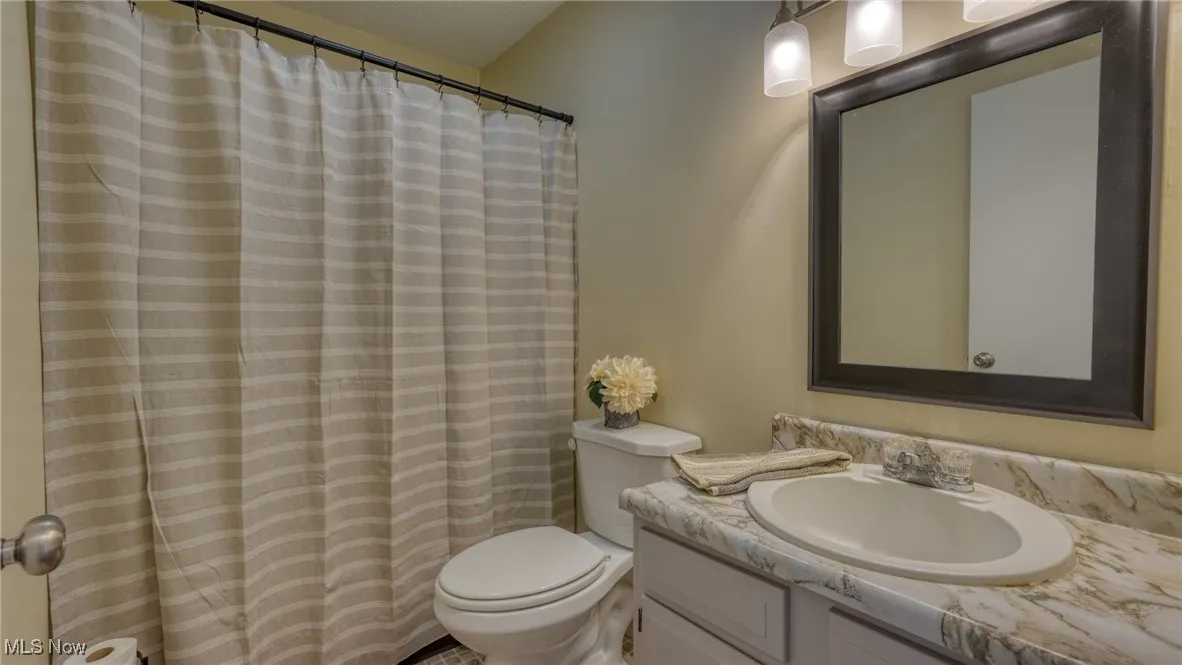 Full bathroom with vanity and a shower with shower curtain