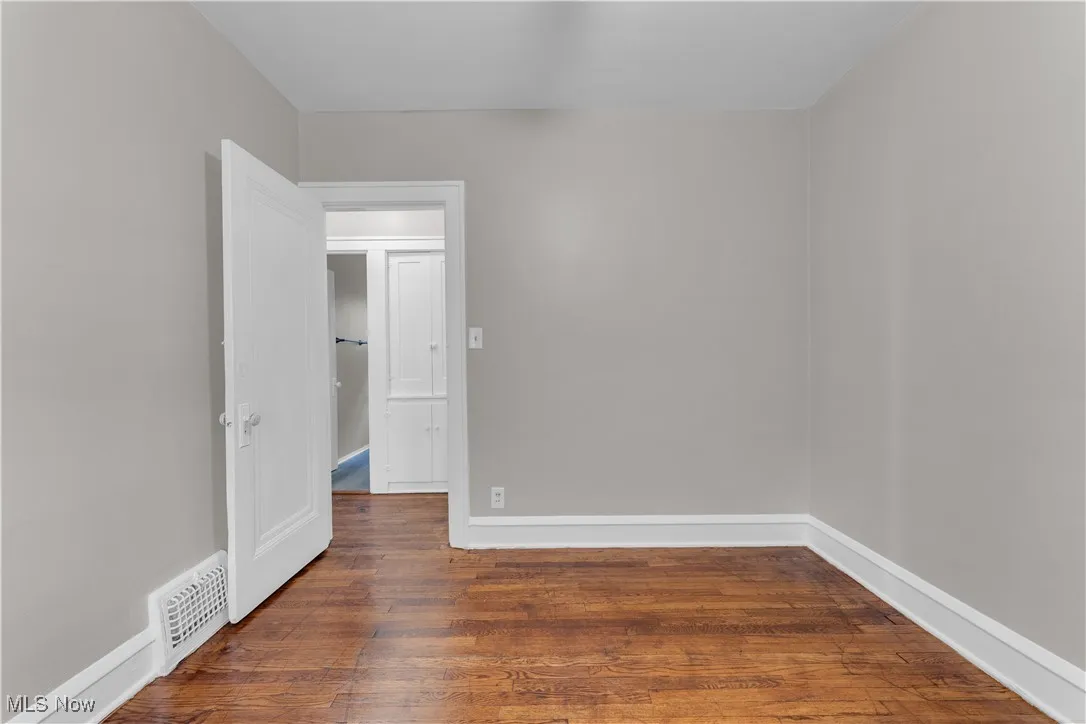 Spare room featuring dark wood finished floors and baseboards