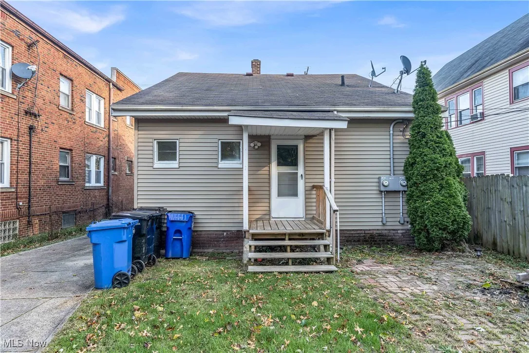 Back of property featuring a chimney and roof with shingles