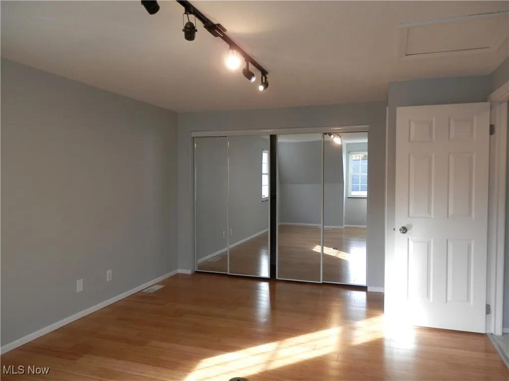 Large bedroom with LVT and wall of closets
