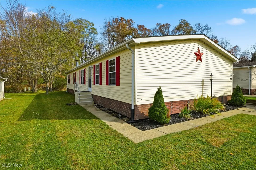 View of side of home featuring a lawn