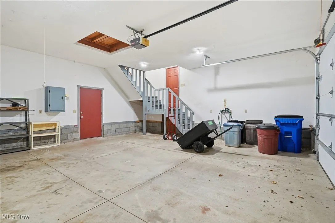 Garage featuring electric panel and a garage door opener