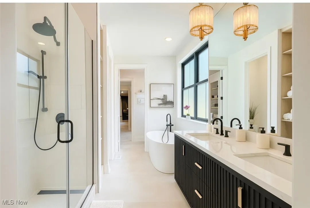 Bathroom featuring a shower stall, a soaking tub, double vanity, and recessed lighting