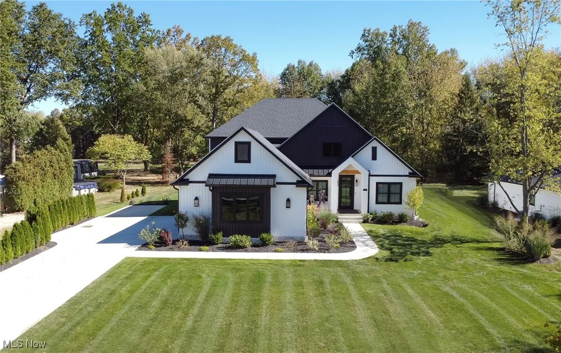 Modern inspired farmhouse featuring a front yard and concrete driveway