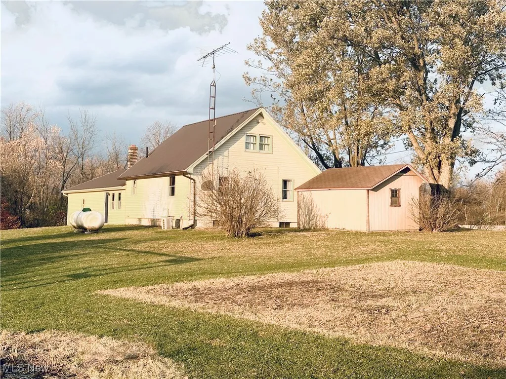 View of side of home with a yard and a chimney