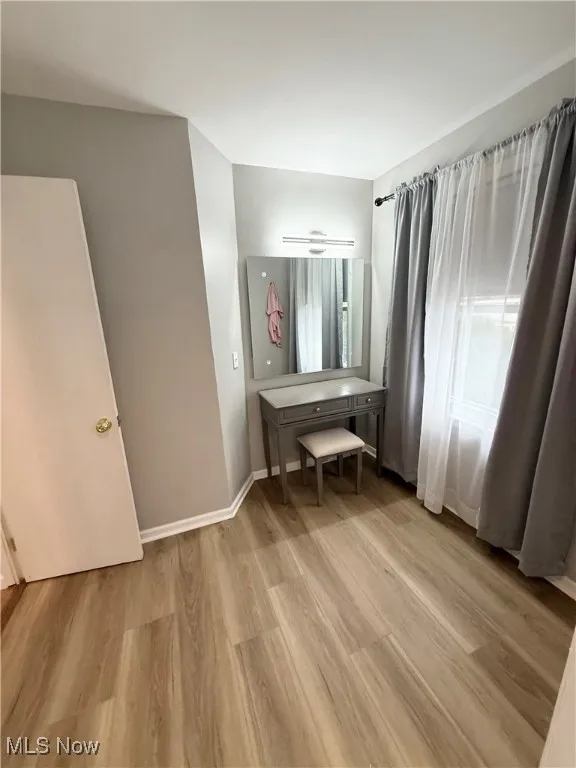 Bedroom with light wood-style floors and baseboards