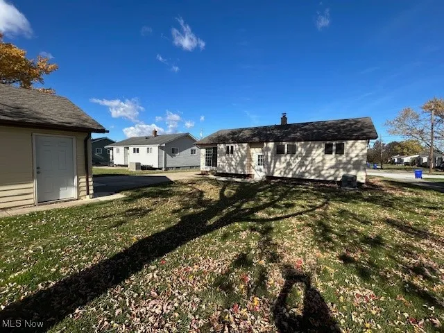 Rear view of house featuring a lawn