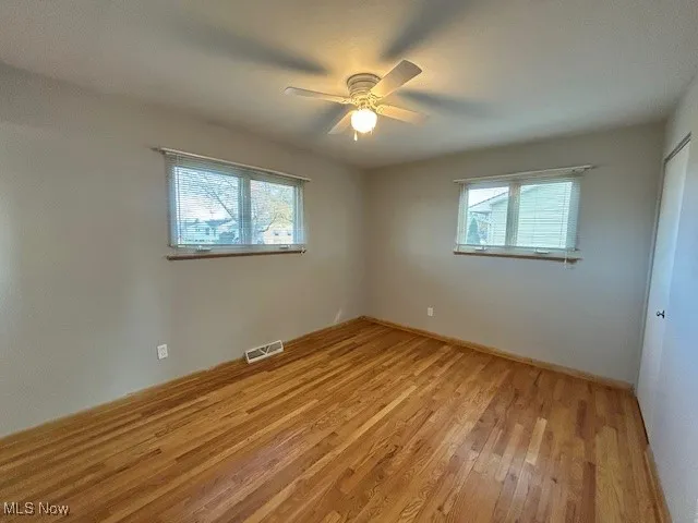 Primary bedroom featuring light wood-style floors and a ceiling fan