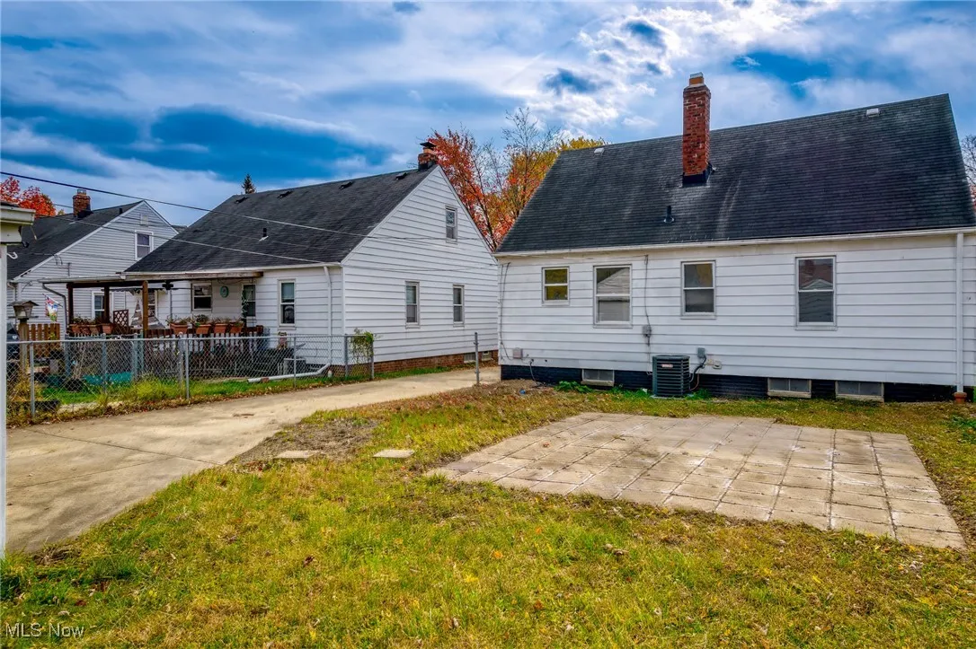 Rear view of house with a patio, a chimney, and a shingled roof