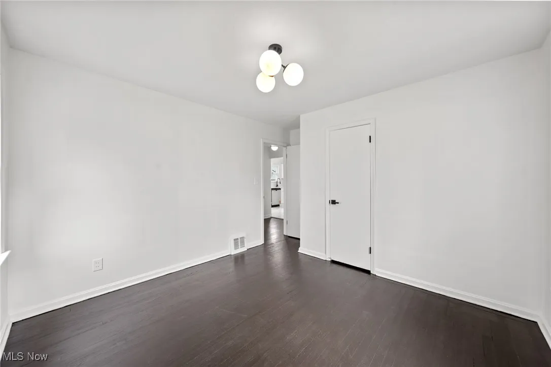 Unfurnished room featuring dark wood-type flooring and baseboards