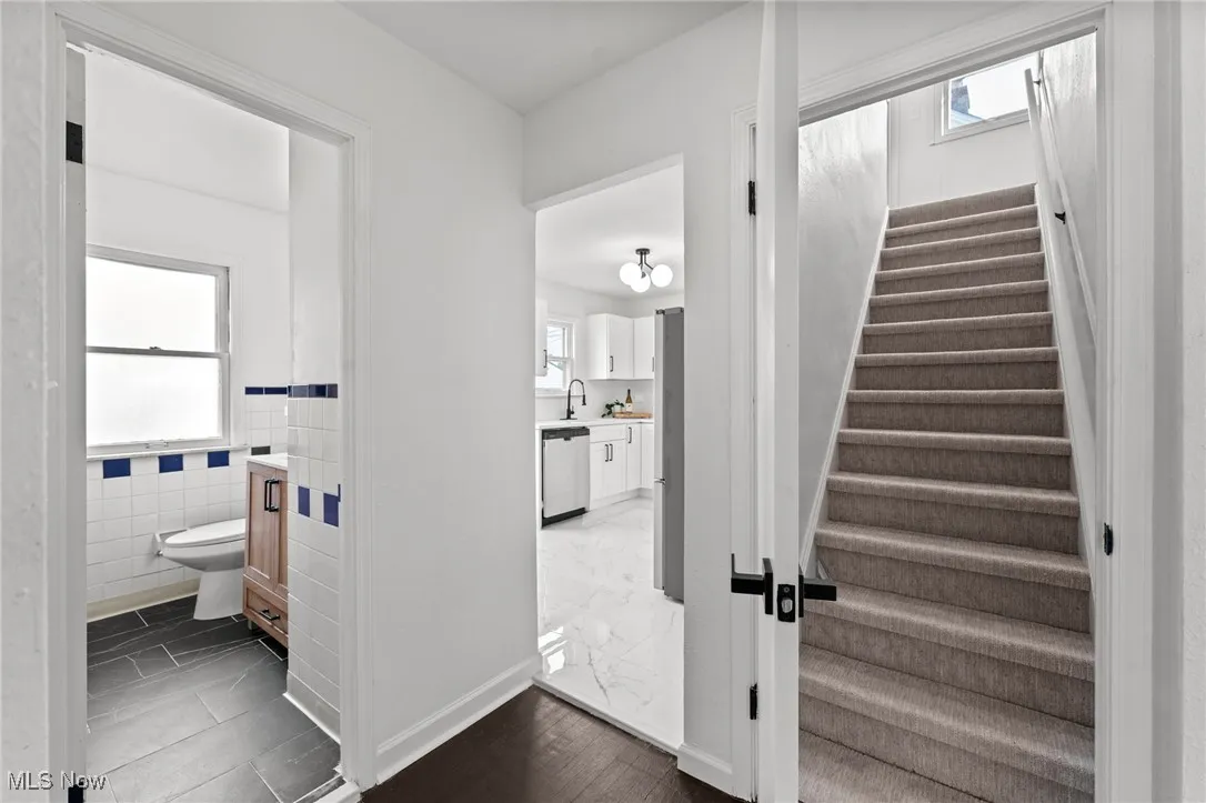 Stairs with tile walls and wood finished floors