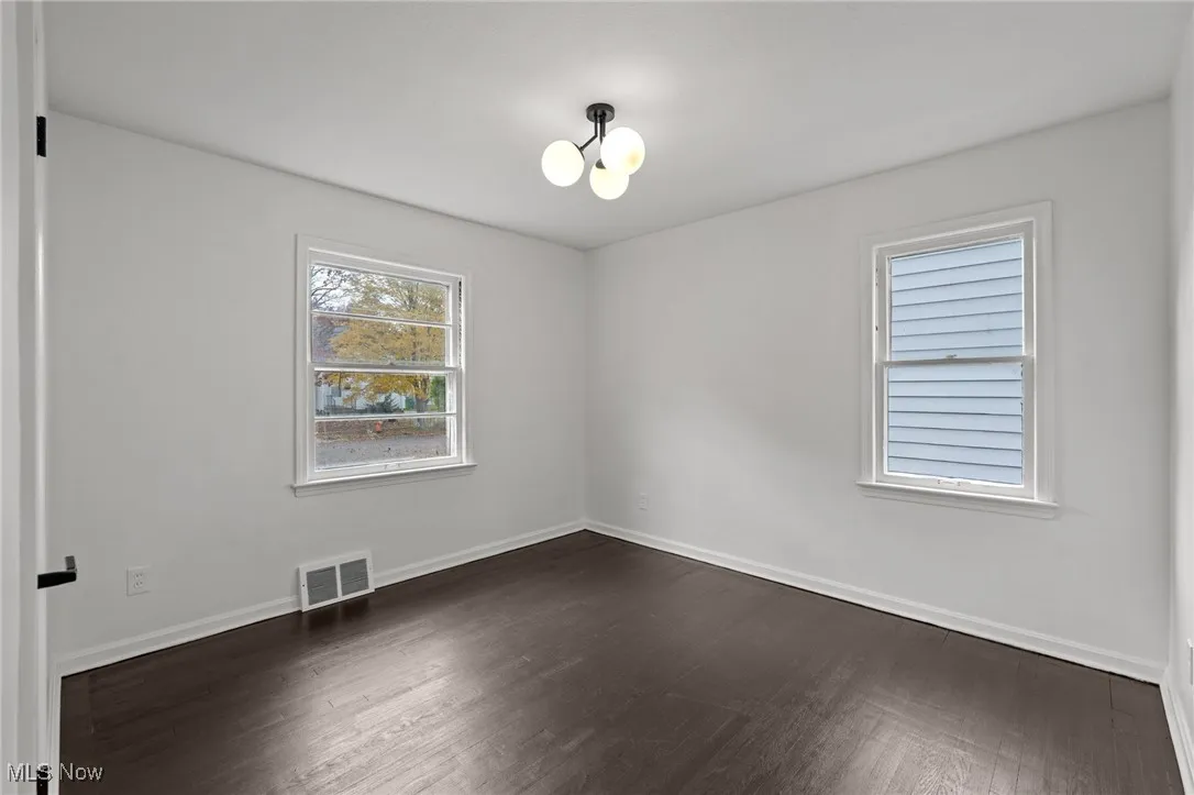 Empty room featuring dark wood-type flooring