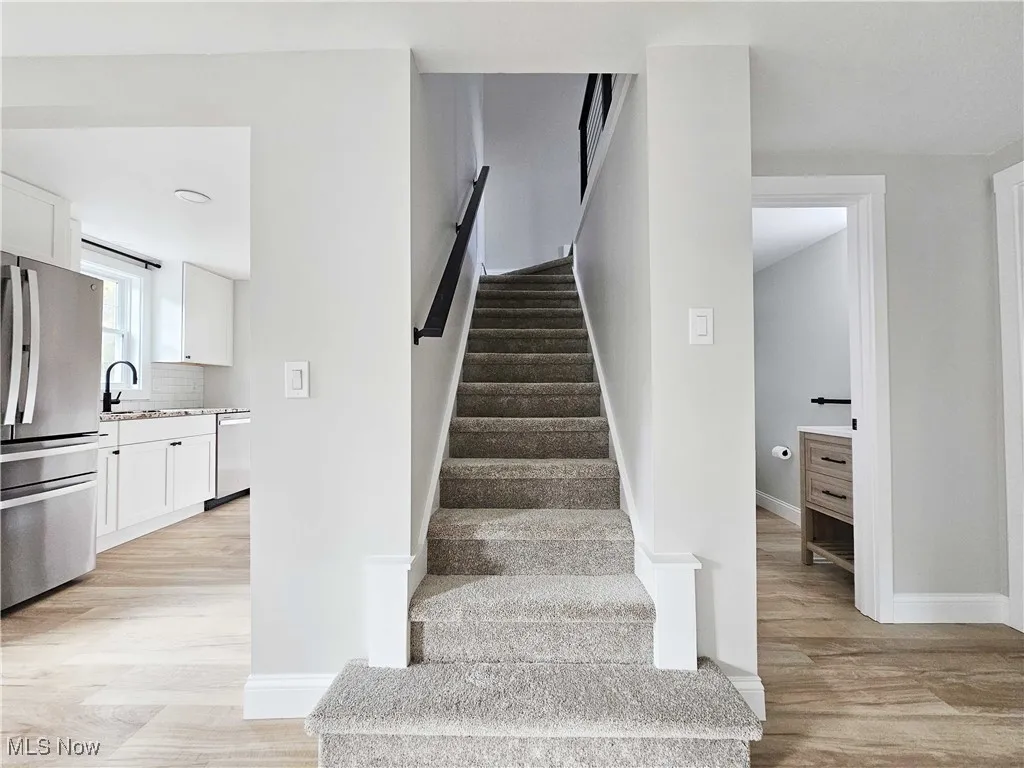 Stairs with wood finished floors and baseboards
