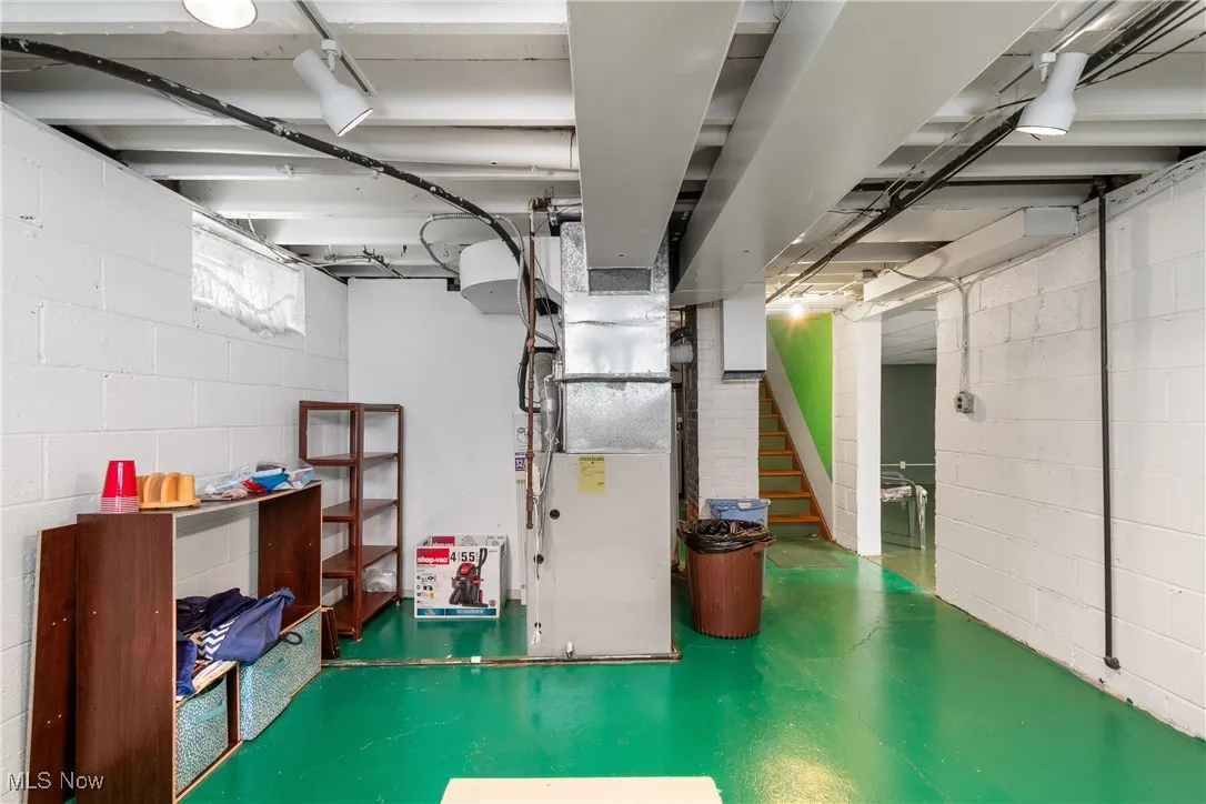 Below grade area featuring heating unit and stairs