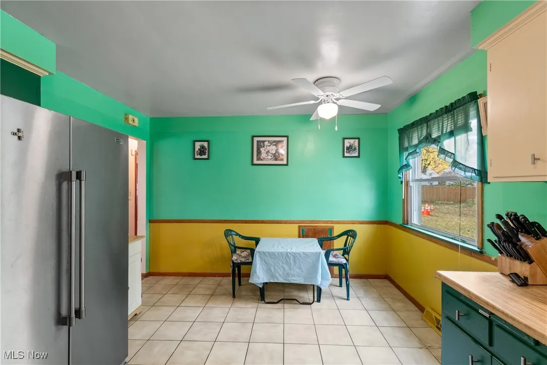 Dining room with ceiling fan and light tile patterned floors